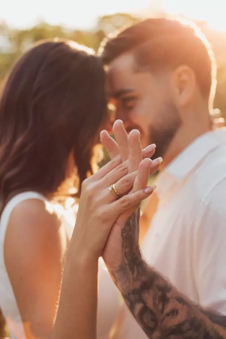Detalhe das mãos de um casal durante ensaio ao pôr do sol